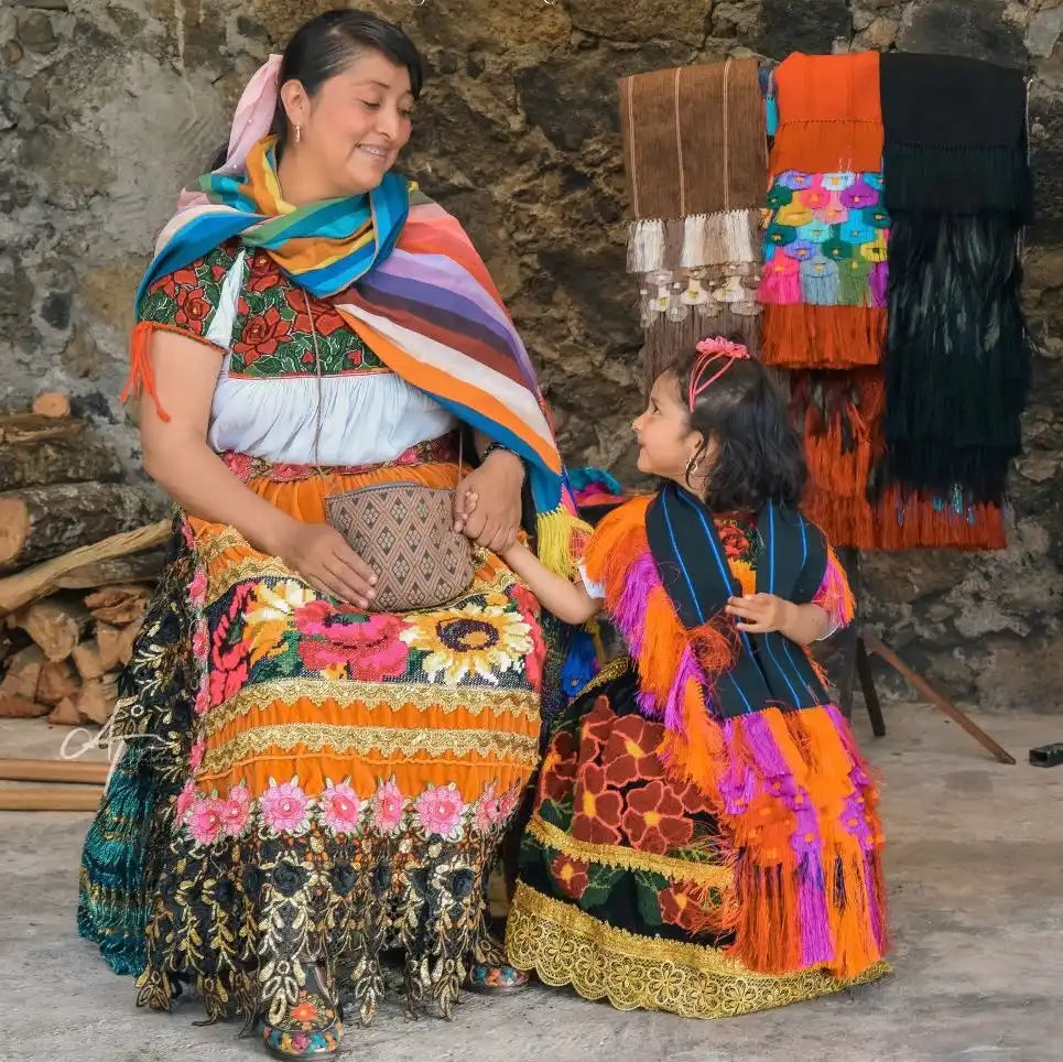 Two women in vibrant traditional clothing.