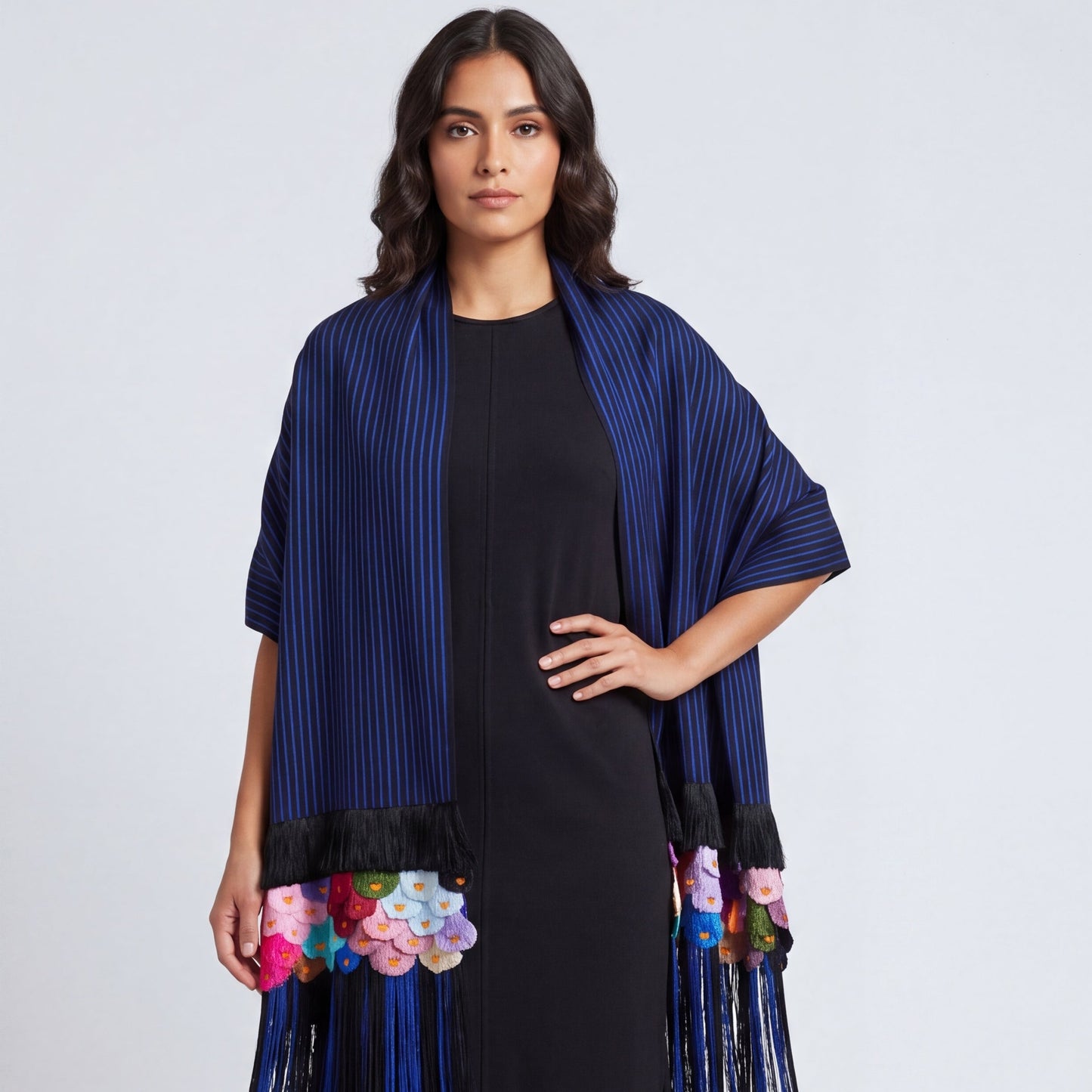 Close-up of hand-tied silk rapacejo fringe detail on blue-stripe Purepecha rebozo
