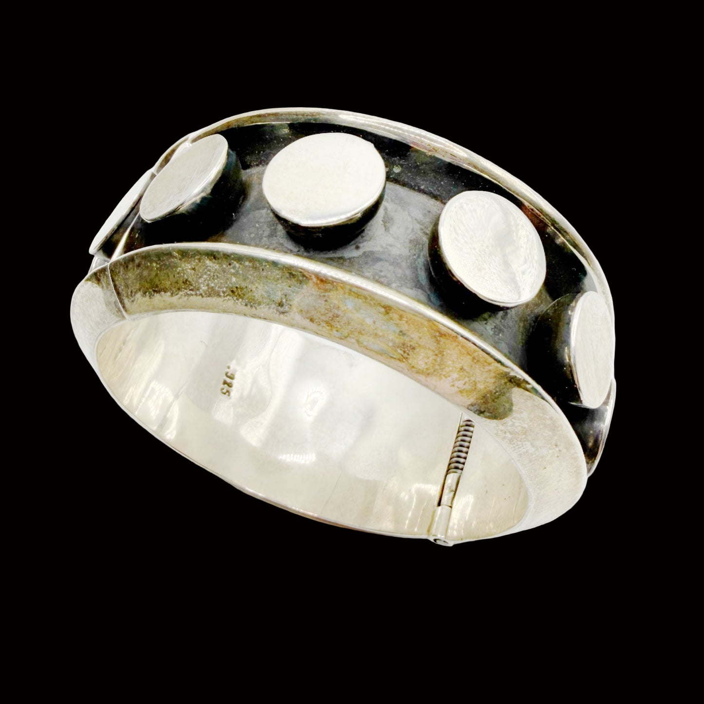 Silver bracelet with three circular stones on a white background