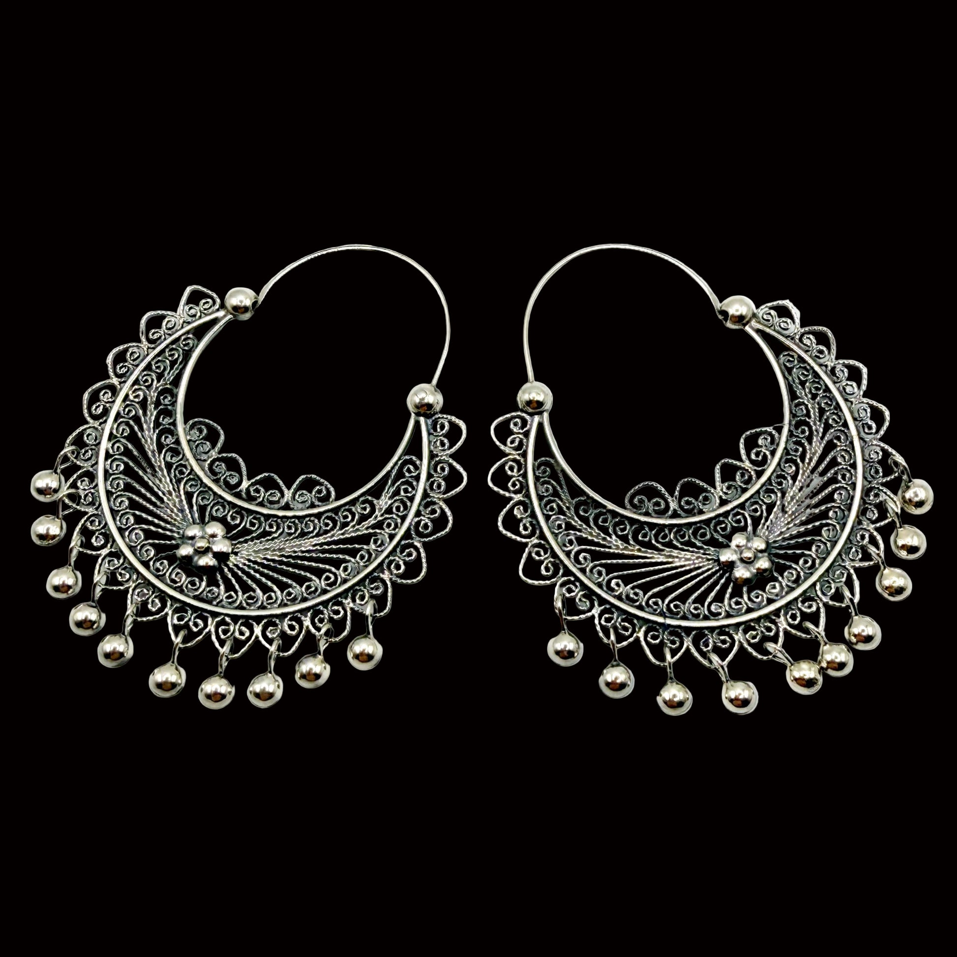 Pair of silver hoop earrings with intricate designs on a white background