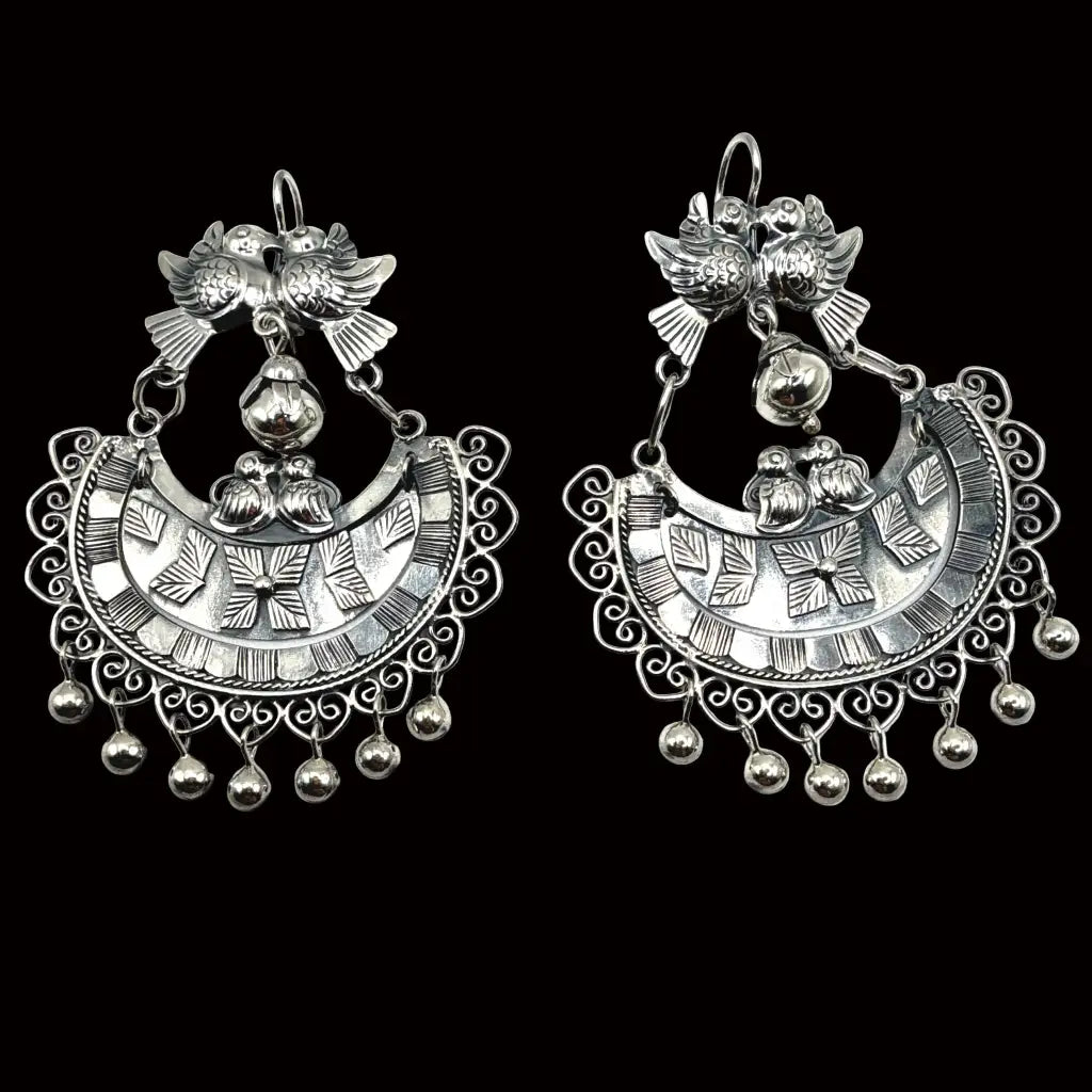Close-up of paloma dove motif and silver sphere details on handmade Mexican Mazahua earrings