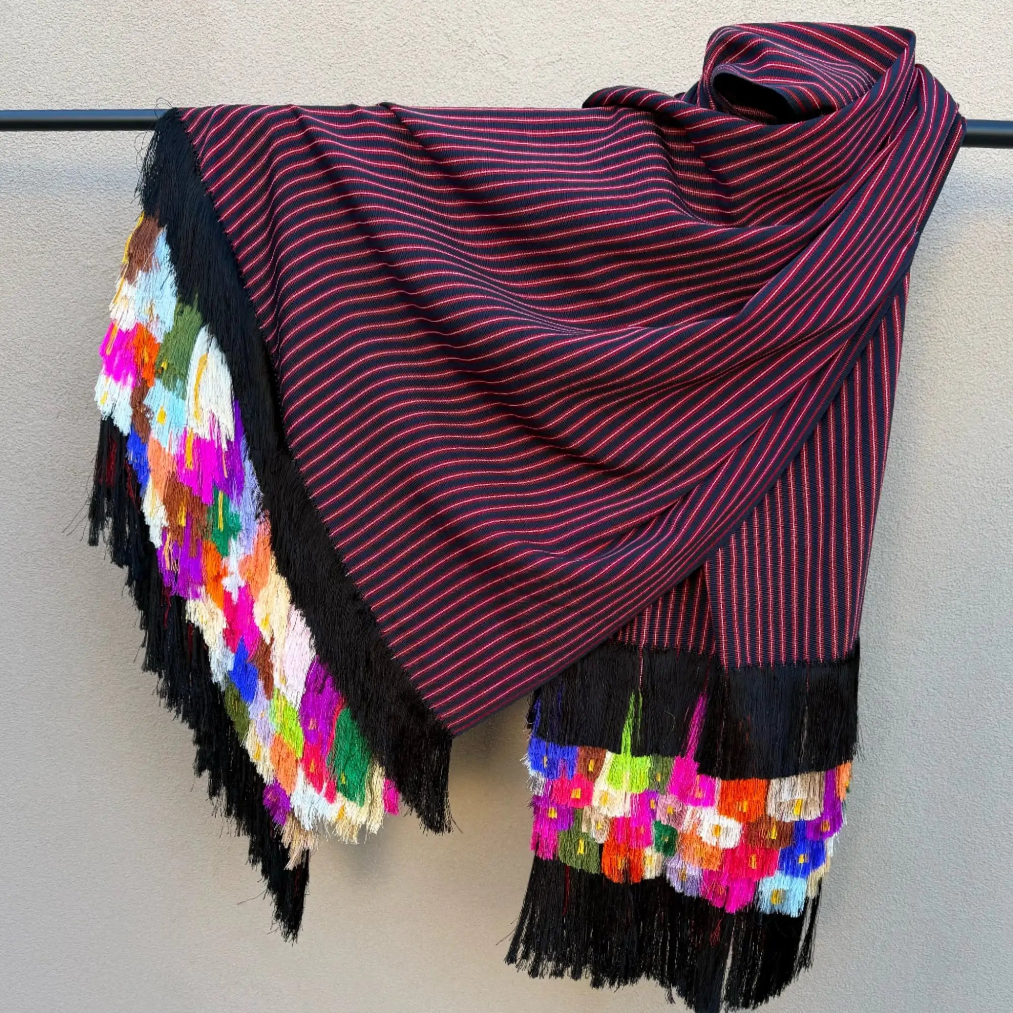 Purple striped scarf with colorful tassels and black fringe.