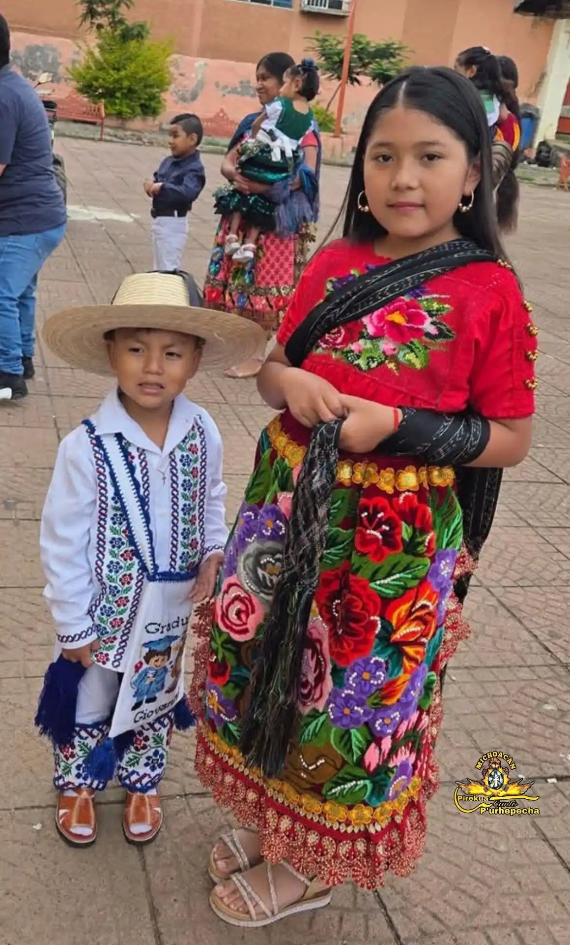 Two children in colorful, embroidered traditional clothing.