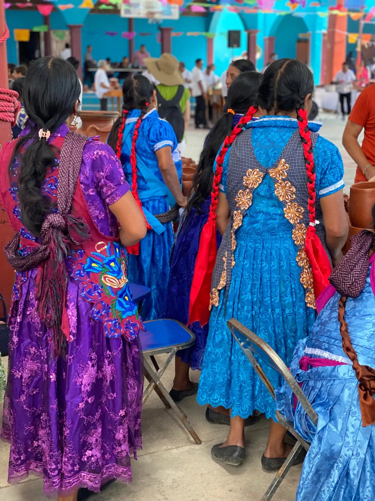 A vibrant purple and blue embroidered dress with intricate floral patterns, featuring a richly detailed back design adorned with golden embellishments.